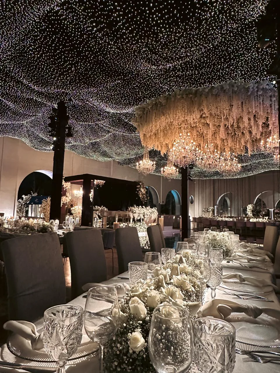 Salón con techo de luces estrelladas y candelabros dorados suspendidos