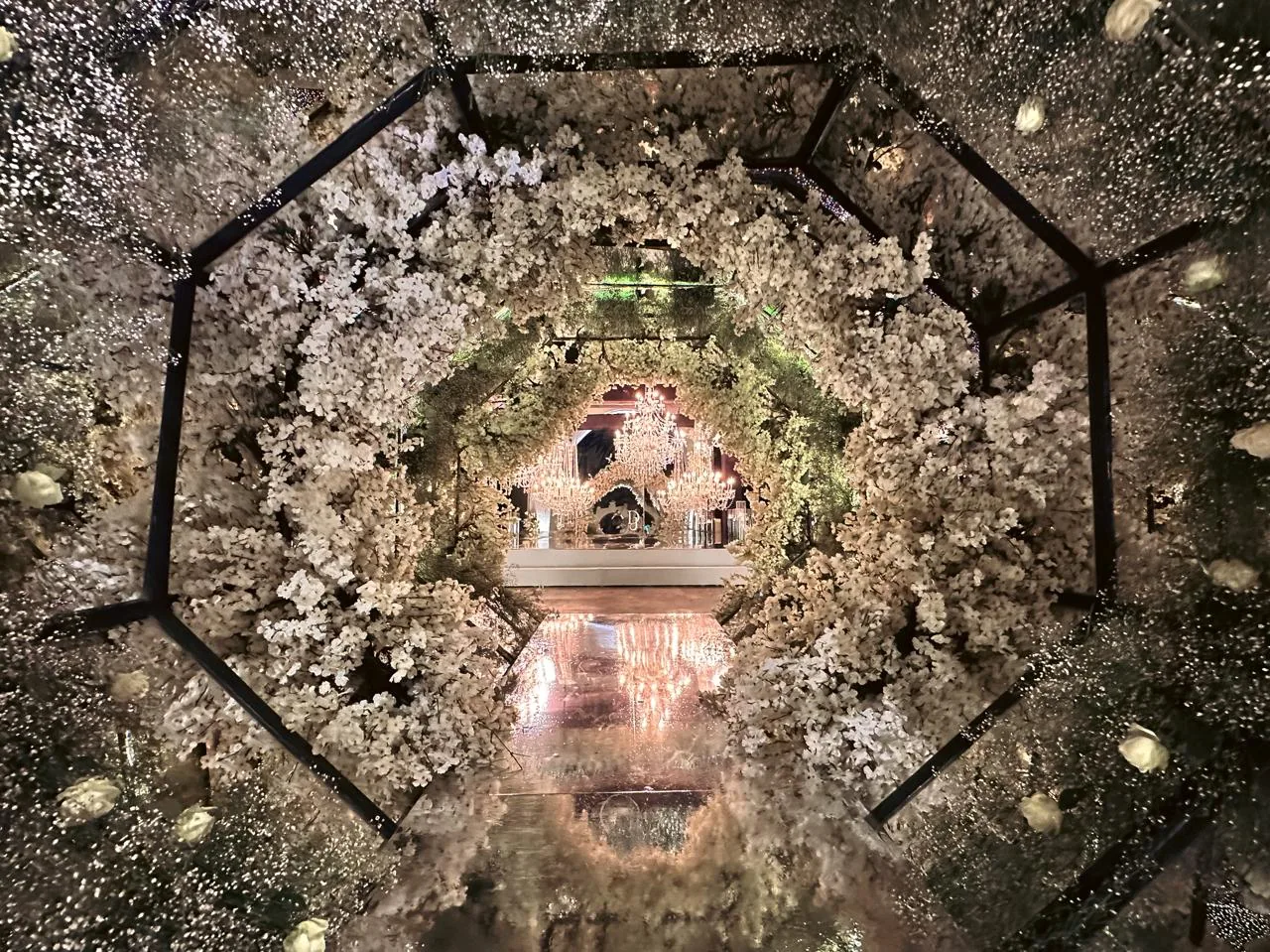 Túnel floral hexagonal blanco hacia altar principal del salón